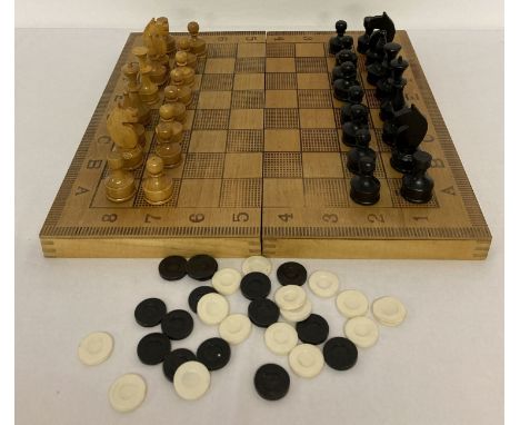 A vintage chess set with wooden folding box/board and playing pieces. Together with a quantity of draughts pieces.