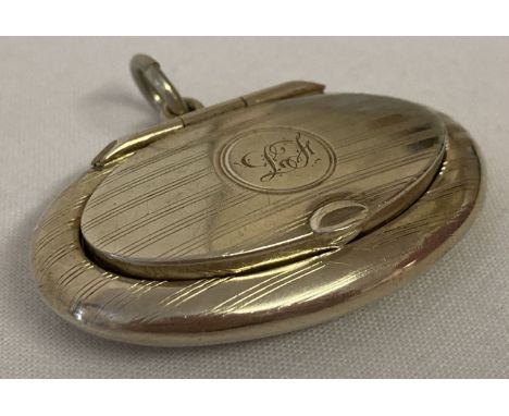 An oval shaped silver pill/snuff box with engine turned decoration. Small mirror to inside of lid.Complete with hanging bale.