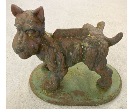 A large vintage heavy cast iron doorstop/boot scraper in the form of a cocked leg Scottie dog. Approx. 33cm tall x 40cm long.