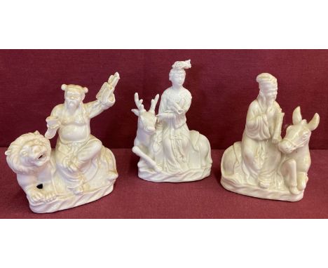 3 Chinese ceramic blanc de chine figurines depicting figures sitting atop animals. Approx. 14cm tall.