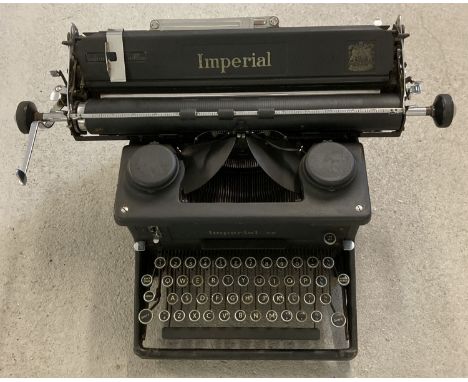 A vintage black metal typewriter by Imperial. Merchant suppliers badge to side for S.R. Batson, Ltd of Ipswich, Cheltenham an