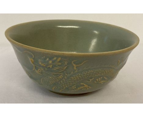 A Chinese ceramic bowl with pale blue glaze and dragon and phoenix design to outer bowl. Approx. 7cm tall x 15.5cm diameter.