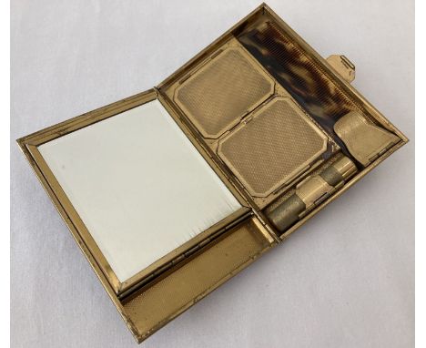 A vintage 1930's metal carry all vanity clutch bag with engine turned decoration. Interior contains powder and cosmetic compa