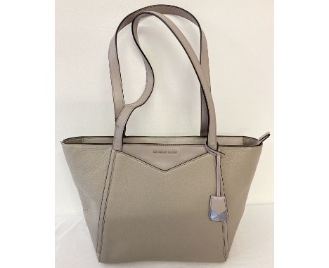 A Michael Kors soft grey leather tote bag. Michael Kors name and hanging charm to front. Zipped top with Michael Kors logo pr