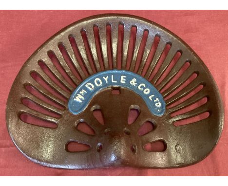 A cast iron painted Wm Doyle &amp; Co. tractor seat.