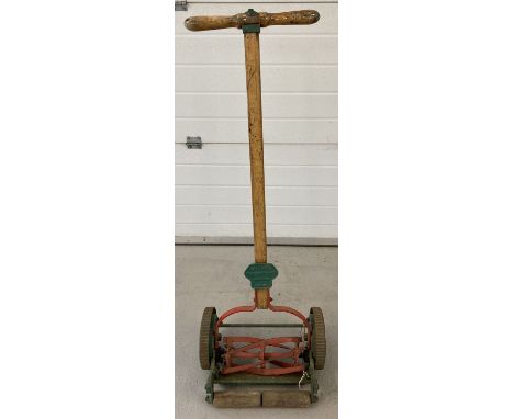 A vintage "The Britisher" hand push lawnmower by Shanks. With small wooden roller and red and green paint work. Approx. 122cm