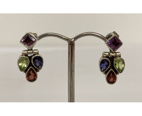 A pair of multi gem set silver modern design drop earrings. Each earring set with a garnet, amethyst, peridot and iolite ston