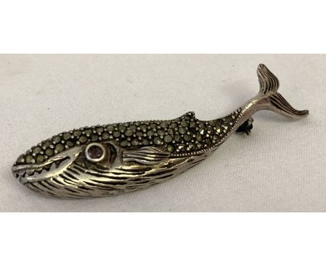 A silver brooch in the shape of a whale set with marcasite stones and an amethyst set eye. Marked 925 to back. 3 marcasite st
