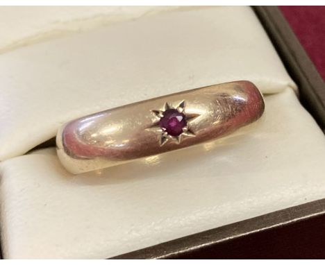 A 9ct gold men's band style ring set with a single small round cut ruby. Size Z. Total weight approx. 6.5g.