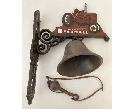 A painted cast iron wall hanging bell with "McCormick Farmall" logo and tractor. Wall hanging bracket approx. 32cm tall.