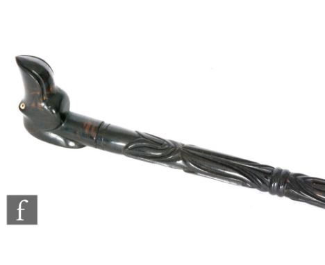 An early 20th Century ebony walking stick worked with a hatched and other carved design with figural handle modelled as a dog