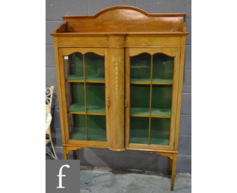 An Edwardian marquetry inlaid mahogany display cabinet, enclosed by a pair of bar glazed doors below a shelf, on square taper