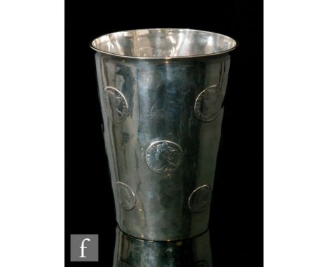 A hallmarked silver large beaker with twelve inset Queen Anne shillings and a half crown to base, height 13cm, Birmingham 190