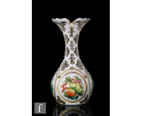 A late 19th to early 20th Century Bohemian glass vase of bottle form with wide rim cased in opal over clear and cut with roun