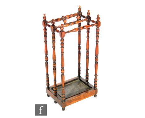 A reproduction twin section walnut stick or umbrella stand in the Victorian style, the turned frame with integral carry handl