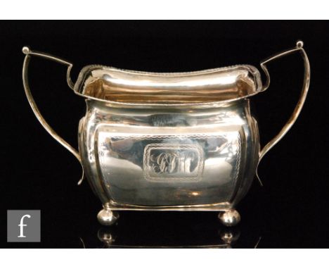 An Irish silver boat shaped, twin handled sugar basin raised on four ball feet below part bright cut decoration and gadrooned