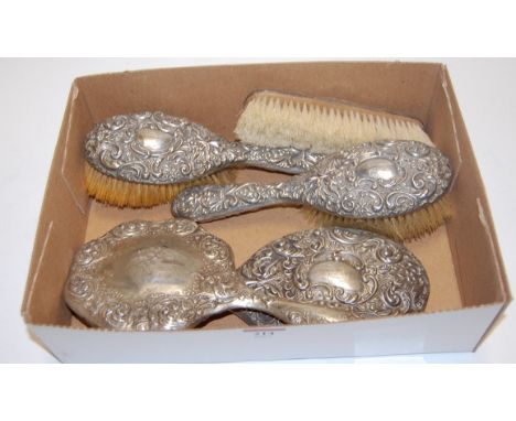 A late Victorian ladies silver mounted three piece dressing table set; together with a similar silver backed hand mirror and 