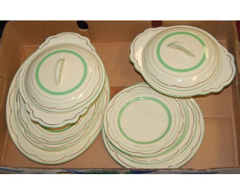 A 1930s Clarice Cliff part dinner service on a cream ground with green and gilt decoration, printed Clarice Cliff Newport Pot