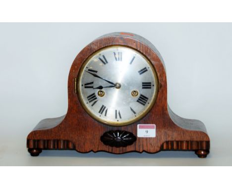 A 1930s oak cased mantel clock having a silvered dial with Roman numerals, and eight day movement striking on a gong