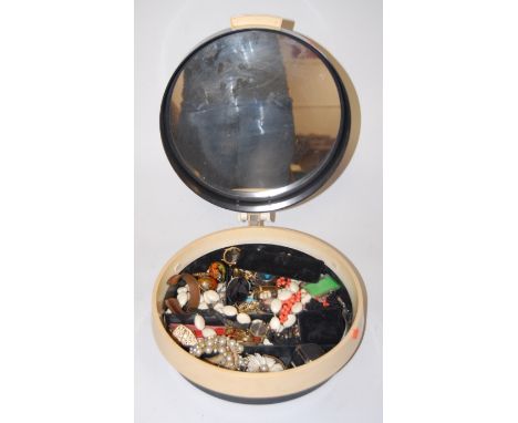 A 1960s ladies vanity case, the hinged lid opening to reveal a mirrored interior, contents to include shell carved cameo broo