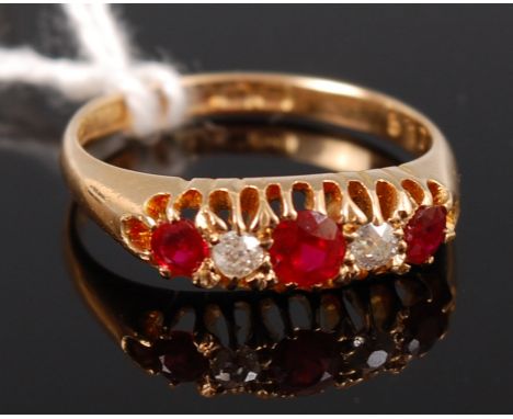 A ladies 18ct gold ruby and diamond dress ring, arranged as three round cut graduated rubies dispersed with two small old bri