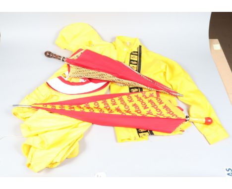 Two Kodak Umbrellas and Two Kodak Rain Macs, one umbrella with Kodak film box design and wood shaft, some fading, fraying oth