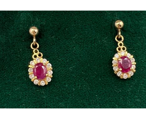 A pair of ruby and diamond cluster drop earrings set in 18 carat gold. Weight 3.3gm. Approximately 1.7cm drop. 