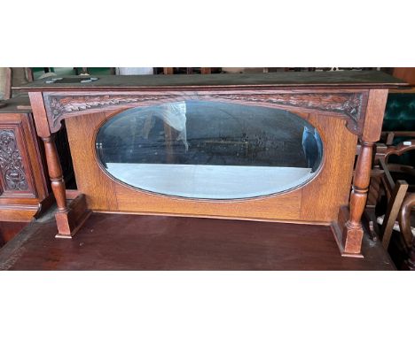 An oak framed mirror with shelf to top and carved decoration. 106cm w x 22cm d x 53 cm h. 