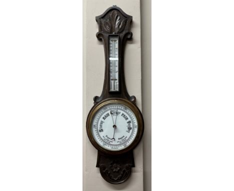 A 20thC oak carved hall mercury barometer with ceramic dial, 81cm h x 26cm at widest point. 