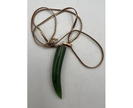 A nine carat yellow gold chain with jade pendant mounted on gold plated ring.  Length of chain approximately 40cm. 3gm. 