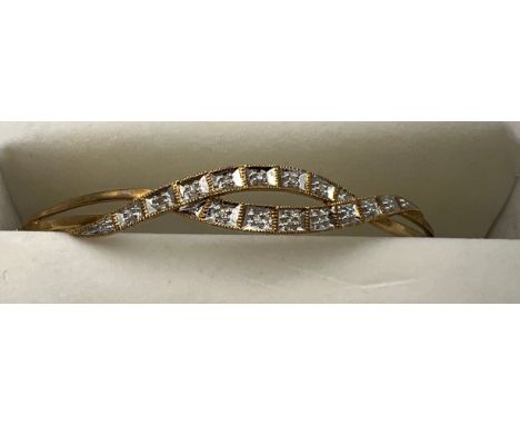 A 9 carat gold hinged bangle set with diamonds. Weight 5.8gm. 6.5cm x 5cm interior measurement. 