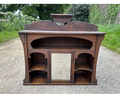 An oak shelf unit with central mirrored door. 83 w x 22 d x 73cm h.