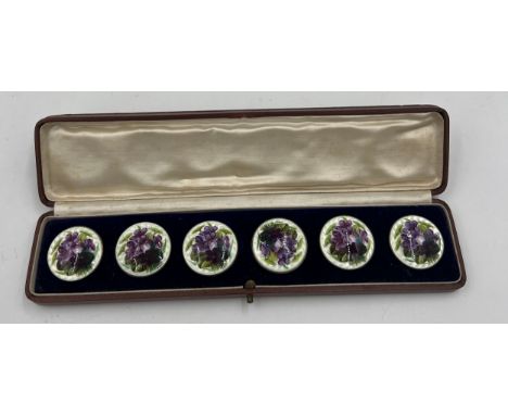 A cased set of six Edwardian .935 silver and enamel buttons decorated with violets in original velvet and silk lined presenta