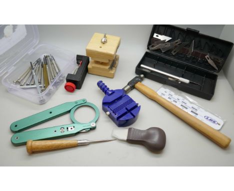 A collection of watchmakers tools, screwdrivers, case vice, opener, hammer, etc.