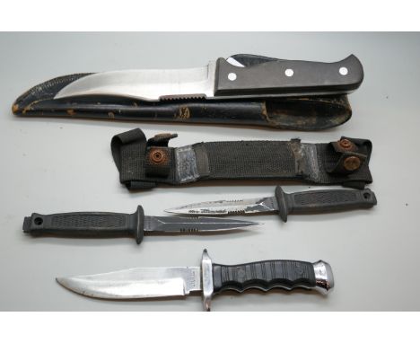 A hunting knife in a leather scabbard, twin daggers in a double scabbard and a dagger lacking scabbard *THIS LOT IS NOT AVAIL