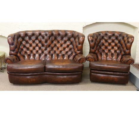 A brown leather deep buttoned two seater sofa and matching fireside armchair.