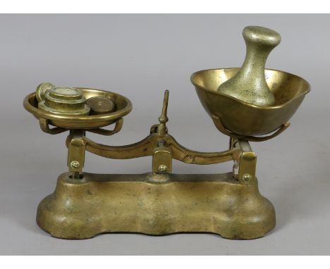 A pair of solid brass weighing scales and weights.