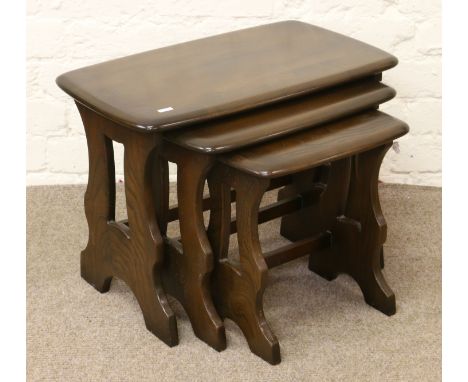 A nest of three Ercol carved oak tables.