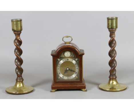 A pair of brass based barleytwist candlesticks and a mahogany cased Elliot mantel clock retailed by Aspreys.