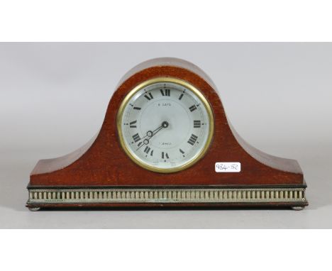 A mahogany cased eight day mantel clock with silvered dial, Roman numeral markers and brass decoration raised on brass bun fe