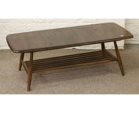 An Ercol carved and turned oak two tier coffee table with magazine storage.