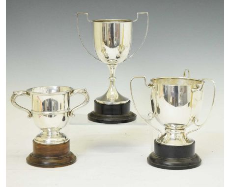 Three silver trophy cups; George V silver three-handled loving cup, Birmingham 1925, 15cm high (without base), George V two-h