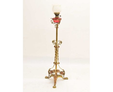 Early 20th century telescopic brass standard lamp with cranberry glass font, 124cm high