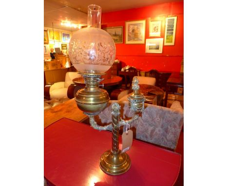 A Victorian brass oil lamp with spherical shade and flume