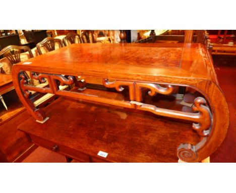 A 19th century Chinese exotic hardwood opium table, the finely figured panel top on carved scroll end supports united by a pi