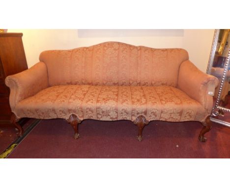 A Queen Anne style four seater sofa upholstered in orange patterned fabric on ball and claw supports  