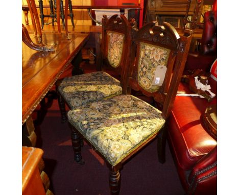 A set of four Victorian carved walnut dining chairs upholstered in tapestry fabric 
