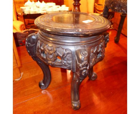 An early 20th century Chinese carved and ebonised hardwood stand, the circular top with incised detail above a pierced carved