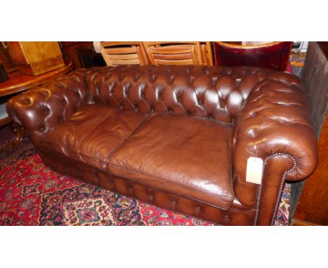 A Chesterfield sofa upholstered in buttoned brown leather with studded detail 