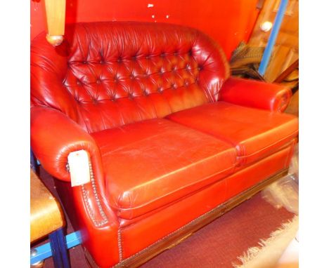 A Chesterfield style two seater sofa upholstered in red buttoned leather 